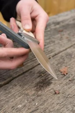 Sharpening knife on whetstone Stock Photos
