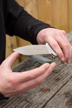 Sharpening knife on whetstone Stock Photos