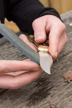 Sharpening knife on whetstone Stock Photos