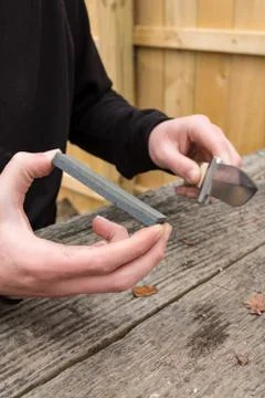 Sharpening knife on whetstone Stock Photos