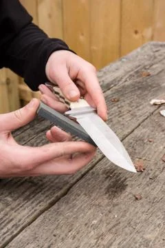 Sharpening knife on whetstone Stock Photos