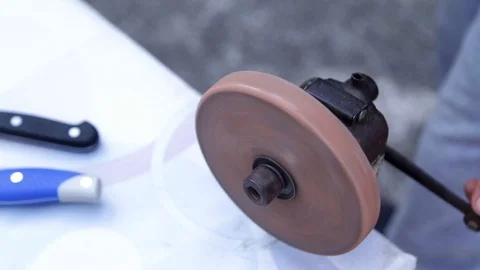 Sharpening knives on crank wheel sharpener Stock-Footage 116983337