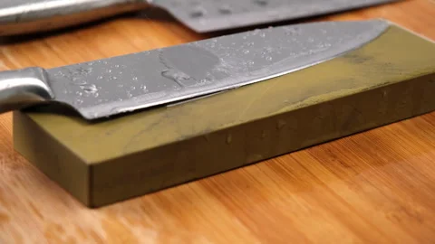 Sharpening knives with a Whetstone. Knife sharpening.  Stock Footage 248340611