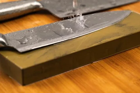 Sharpening knives with a Whetstone. Knife sharpening.  Stock Photos