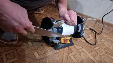 Sharpening a large knife using a sharpening machine in a home setting Stock Footage 336912817