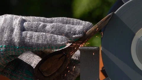 Sharpening of old ax with unbalanced grinding machine in slow motion close up. Stock Footage 98677788