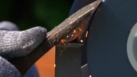 Sharpening of old ax with unbalanced grinding machine in slow motion close up. Stock Footage 98678146