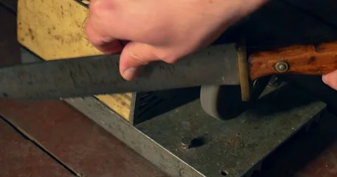 Sharpening the old knife on the grinding machine. Close-up Stock Footage 98212761