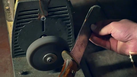 Sharpening the old knife on the grinding machine. Close-up. Slow motion Stock Footage 98213070