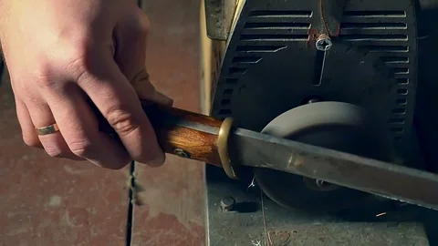 Sharpening the old knife on the grinding machine. Close-up. Slow motion Stock Footage 98213099