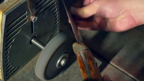 Sharpening the old knife on the grinding machine. Close-up. Slow motion Vídeo Stock 98213171