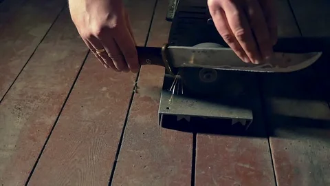 Sharpening the old knife on the grinding machine. Close-up. Slow motion Stock Footage 98213836