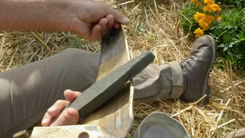 Sharpening the scythe with a whetstone Stock Footage 162500053