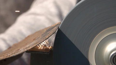 Sharpening of soiled garden tool with unbalanced grinding machine in slow motion Stock Footage 98676504