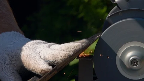 Sharpening of soiled garden tool with unbalanced grinding machine in slow motion Stock Footage 98676884