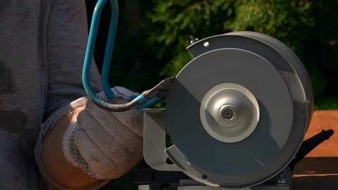 Sharpening of soiled garden tool with unbalanced grinding machine in slow motion Stock Footage 98677667