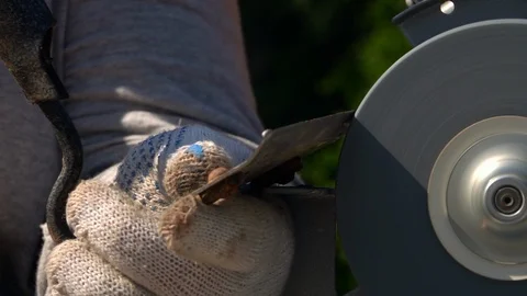 Sharpening of soiled garden tool with unbalanced grinding machine in slow motion Video stock 98677689