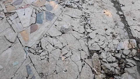 Shattered concrete surface with deep cracks and fragments close-up view Видео 342586456