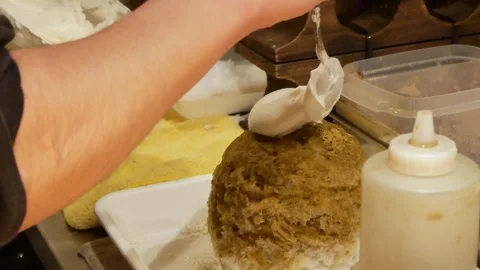 The shaved ice while slightly putting milk cream cheese topped on the caram.. Stock Footage 302385264