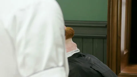 Shaving of beard. Man after cutting men's face hair by barber at barbershop. 4K Stock Footage 92386973