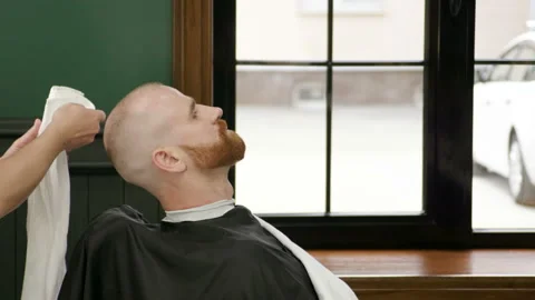 Shaving of beard. Man after cutting men's face hair by barber at barbershop. 4K Video stock 92387024