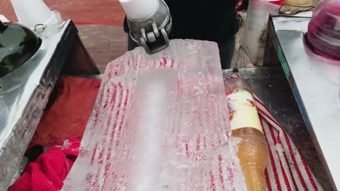 A Shaving ice off of ice block for snow cones Stock Footage 155456199