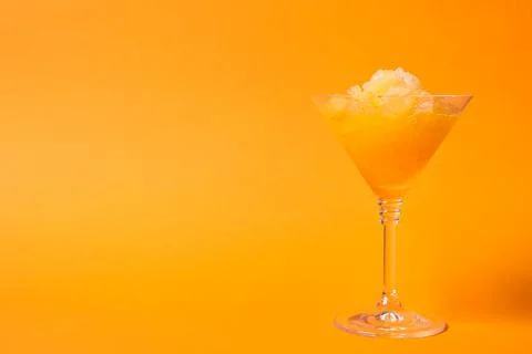 Shaving ice in martini glass on orange background, space for text Stock Photos