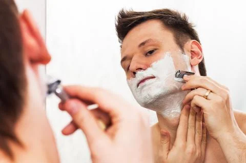 Shaving man in the mirror Stock Photos