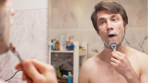 Shaving man reflected in the mirror Stock Footage 128916791