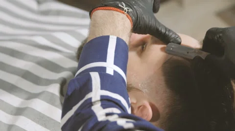 Shaving process of beards in Barbershop. Master makes a haircut beard client Stock Footage 64570542