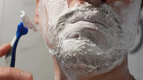 Shaving thick stubble with a disposable shaving machine. Close-up of shaving. Stock Footage 273789042