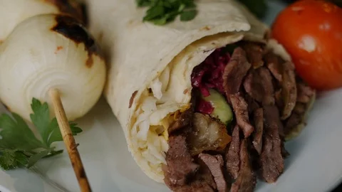 Shawarma is a dish in Middle Eastern cuisine consisting of meat and vegetables. Stock Footage 121421621