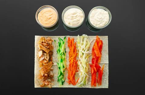 Shawarma ingredients. On a thin flat cake: grilled meat, cucumber, carrots, c Stock Photos