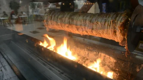 Shawarma machine rotating and grilling meat with spices.flashes of fire Vídeos de archivo 95018074
