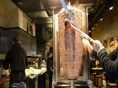 Shawarma meat being cut before making a sandwich, Doner Kebab Vidéo 77081001