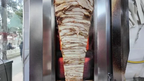 Shawarma meat turning on spit grilling with visible flames cinematic food p.. 스톡 동영상 332879944