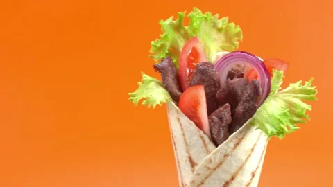 Shawarma moves on an orange background. 库存影片 143767451