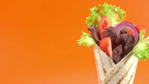 Shawarma moves on an orange background. 库存影片 143767459