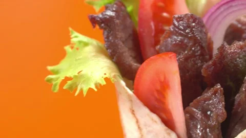 Shawarma moves on an orange background. 库存影片 143767530