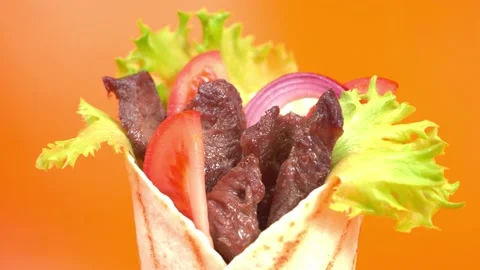 Shawarma moves on an orange background. 库存影片 143767631
