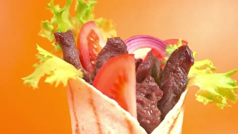 Shawarma moves on an orange background. 库存影片 143767640