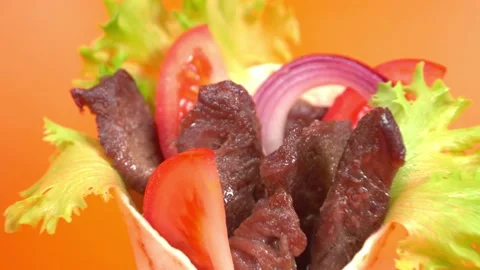 Shawarma moves on an orange background. 库存影片 143767660