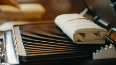 Shawarma is placed on an open hot electric grill for further cooking. Stock Footage 234772333