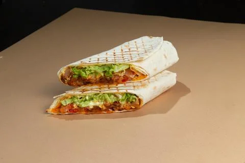 Shawarma. Roll. With greenery on a brown background. Foto stock