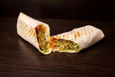 Shawarma sandwich - fresh roll of thin lavash (pita bread) filled with grille Stock Photos