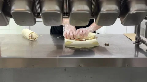 Shawarma Wrap Tightly Rolled by Gloved Cook on Kitchen Counter with Fresh Meat Stock Footage 345173651