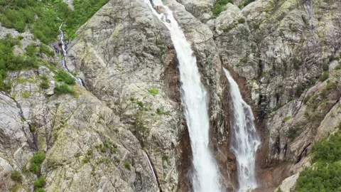 Shdugra Waterfall cascades in hovering aerial view down a steep rocky face below Stock Footage 343539873