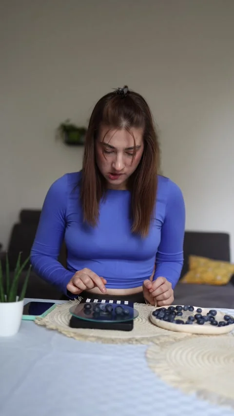 She adds blueberries one by one by calories Stock Footage 339855324
