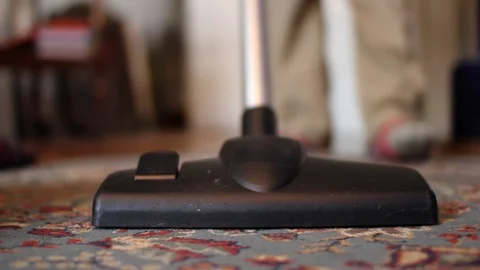 She aspires a thick carpet which is placed on the floor of the house Stock Footage 96708339