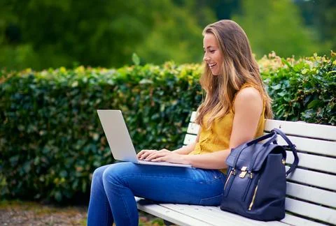 She blogs about things that make her happy. a young woman using a laptop on a Stock Photos